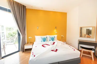 a bedroom with a large white bed with red flowers on it at Teetara Villa Patong in Patong Beach
