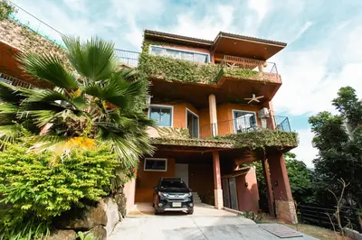a house with a car parked in front of it at Teetara Villa Patong in Patong Beach