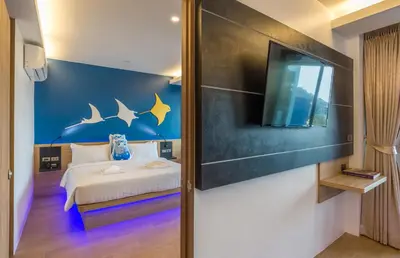 a bedroom with a bed and a tv on a wall at Anda Sea Tales Resort-SHA Plus in Ao Nang Beach