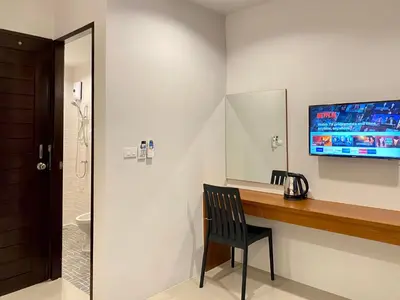 a bathroom with a desk with a chair and a television at Pensiri House - SHA Extra Plus in Nai Yang Beach