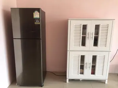 a black refrigerator next to a white cabinet at Connexion in Ko Yao Noi