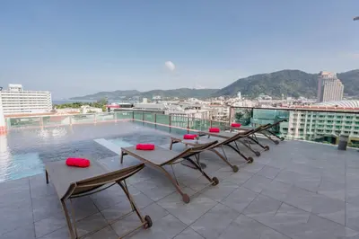 a group of tables on the roof of a building at SLEEP WITH ME HOTEL design hotel @ patong (SHA Plus+) in Patong Beach