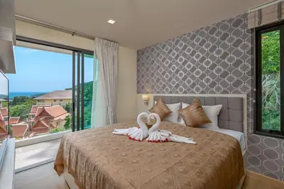 a bedroom with two swans towels on a bed at Splendid Sea View Resort in Kata Beach