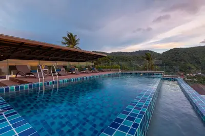 a swimming pool with blue tiles in a resort at Splendid Sea View Resort in Kata Beach