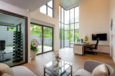a living room with a table and a desk with a wine bottle at Splendid Sea View Resort in Kata Beach