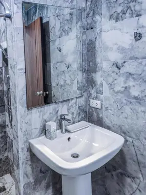 a bathroom with a white sink and a mirror at MBC Mai Khao Beach Condotel LUXURY APARTMENTs in Phuket Town
