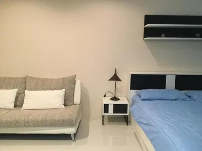 a bedroom with two beds and a couch at Best Point Condominium Cape Panwa in Phuket Town