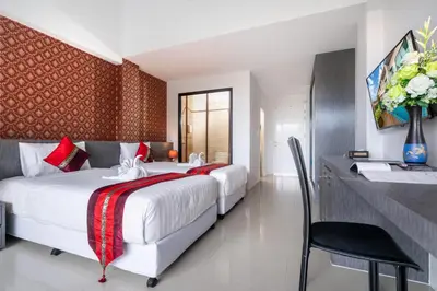 a hotel room with two beds and a desk at The Thames Pool Access Resort & Villa - SHA Extra Plus in Chalong