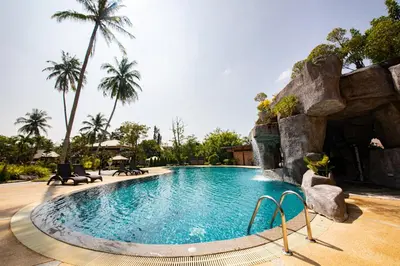 a swimming pool in a resort with palm trees at Rnana Grand in Phangnga