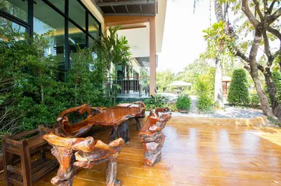 a wooden bench sitting outside of a building at Rnana Grand in Phangnga