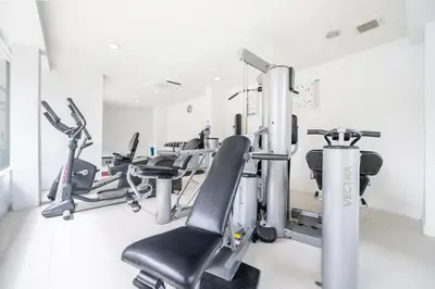 a gym with cardio equipment in a white room at Hotel COCO Phuket Bangtao Beach in Bang Tao Beach