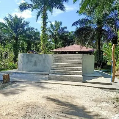 a building with stairs and a building with palm trees at Koom Kachanaan in Ban Nong Thale