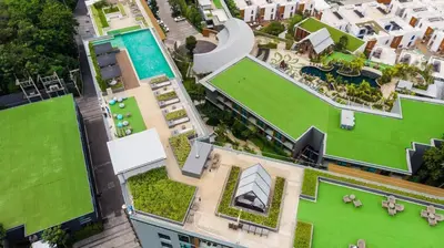 an overhead view of a building with a pool and grass at Panora Condo by Villacarte in Surin Beach