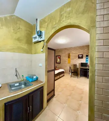 a kitchen with a sink and a room with a bedroom at Sanuk bungalows in Rawai Beach