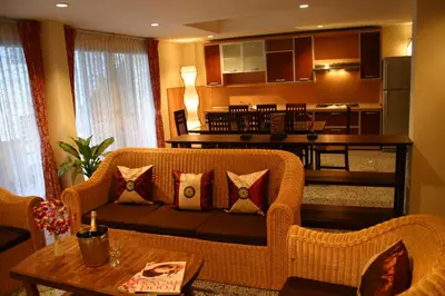 a living room with a couch and a kitchen at Tolmaj Family Apartment in Ao Nang Beach