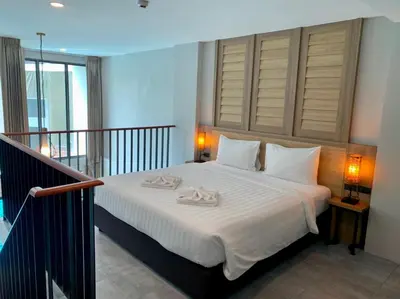 a bedroom with a bed with two towels on it at Atom Phuket Hotel in Nai Yang Beach