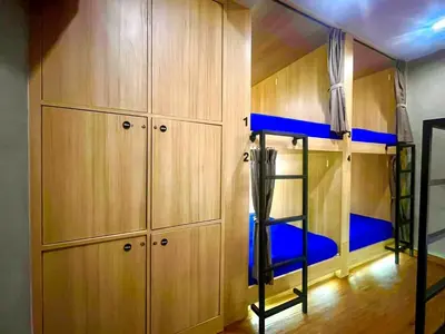 a bunk bed in a room with wooden cabinets at Patong Poshtel in Patong Beach