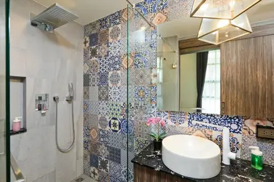 a bathroom with a sink and a shower with a mirror at The Sea View room in Palmyrah Surin by Holy Cow in Surin Beach
