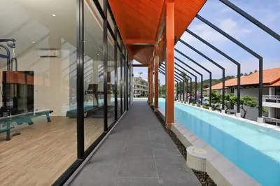 an external view of a building with a swimming pool at The Palmyrah Surin by Holy Cow, 1-BR, courtyard or pool view in Surin Beach