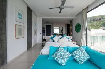 a bedroom with a large bed with blue pillows at Villa Omari 5Bedroom with Pool near Kata Beach in Kata Beach