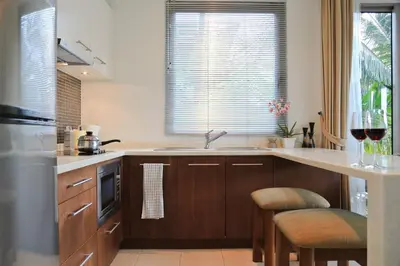 a kitchen with a sink and a counter with stools at Kata gardens luxury 2bedroom 4B Near Kata Noi Beach in Kata Beach