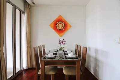 a dining room with a table with chairs and a picture on the wall at Kata gardens luxury 2bedroom 4B Near Kata Noi Beach in Kata Beach