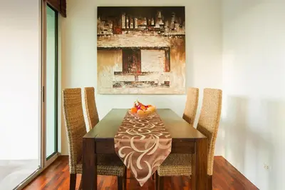 a dining room table with two chairs and a bowl of fruit on it at Ocean views Kata gardens penthouse 6C near Kata Noi Beach in Kata Beach