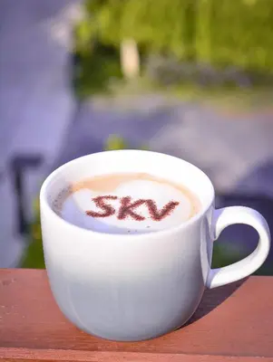 a cup of cappuccino with the word kiss written on it at SKYVIEW Resort Phuket Patong Beach in Patong Beach
