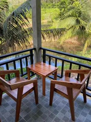 three wooden benches and a table on a balcony at Green Mountain Resort Koh Yao in Ko Yao Yai