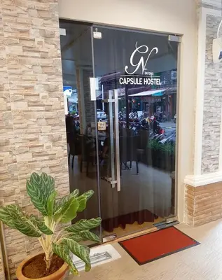 a restaurant door with a potted plant in front of it at GN Capsule Hostel Patong in Patong Beach