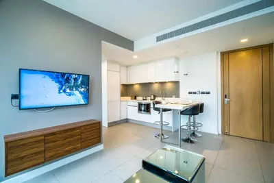 a large living room with a tv on the wall at Oceanstone Resort by Lofty in Bang Tao Beach