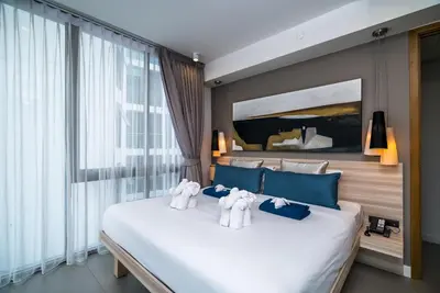 a bedroom with a large bed with two stuffed elephants on it at Oceanstone Resort by Lofty in Bang Tao Beach