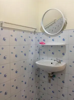 a bathroom with a sink and a mirror on the wall at Wattana Bungalow in Nai Yang Beach