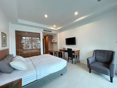 a bedroom with a bed and a chair and a desk at Clear House Resort - SHA Extra Plus in Kamala Beach