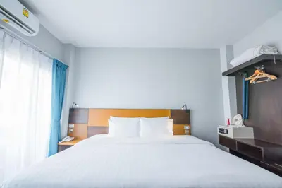 a bedroom with a large white bed and a window at Naina Resort & Spa - SHA Extra Plus in Patong Beach