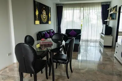 a living room with a dining room table and chairs at Rawai Paradise in Rawai Beach