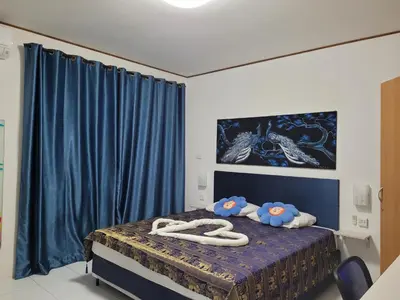 a bedroom with a bed with two towels on it at B&B NAMO PHUKET in Kathu
