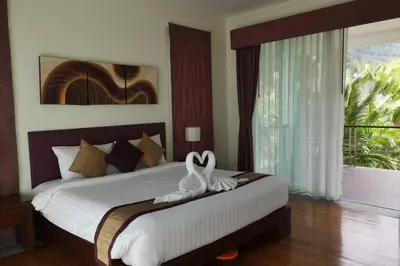 a bedroom with a large white bed with a window at 4 Bedroom Villa Kamala Beach Phuket in Kamala Beach