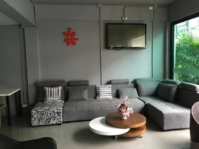 a living room with a couch and a tv at Chalong Sea Breeze in Chalong