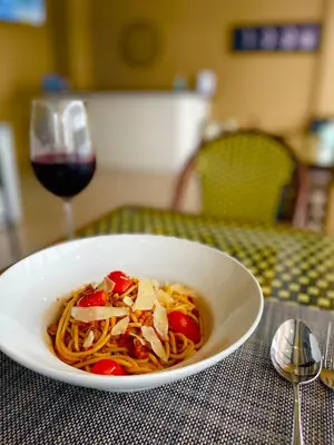 a bowl of spaghetti and a glass of wine at The Little Moon Residence in Patong Beach