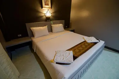 a bedroom with a large white bed with two bags on it at The Little Moon Residence in Patong Beach