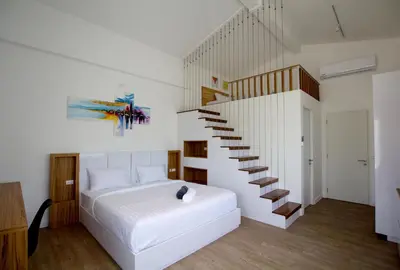 a bedroom with a white bed and a staircase at Happy Family Villa in Phuket Town