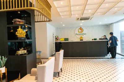 a man standing at a counter in a restaurant at Peranakan House in Phuket Town