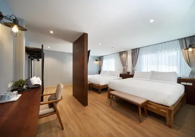 a hotel room with two beds and a desk at P2 Wood Loft in Phi Phi Don