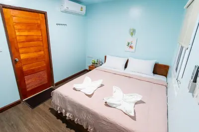 a bedroom with a bed with two white flowers on it at Aladdin Guest House in Phi Phi Don