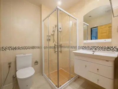 a bathroom with a shower and a toilet and a sink at Naithon Beachfront Condotel in Nai Thon Beach