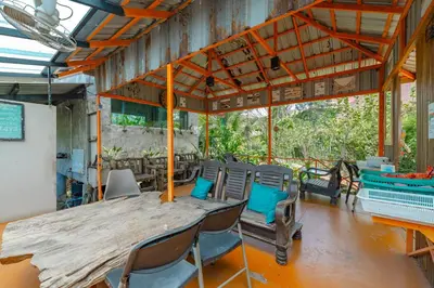 a room with a large wooden table and chairs at Coco Paradiso Phuket SHA in Phuket Town