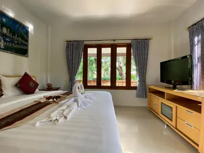 a bedroom with two beds and a flat screen tv at Yuwadee Resort in Chalong