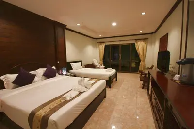 a hotel room with two beds and a television at Baan Veerakit Hotel in Patong Beach