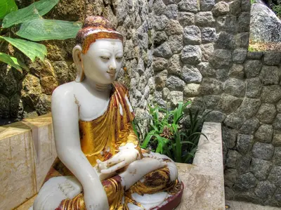 a statue of a woman sitting on a stone ledge at Villa Minh in Kamala Beach